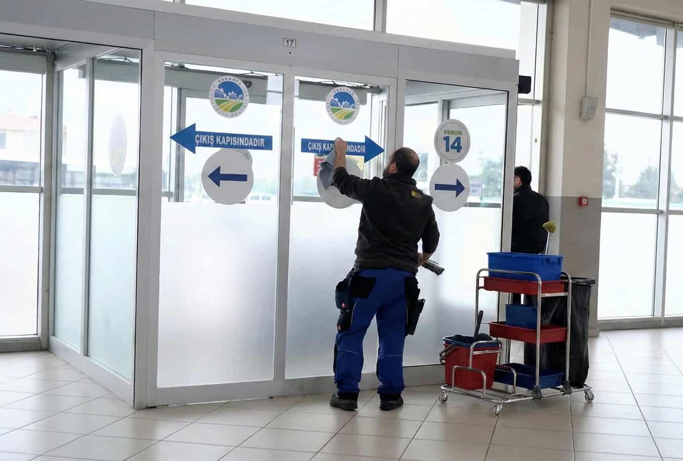 Güvenlik kapısından giriş ve çıkış yönlerini gösteren güvenlik görevlisi.